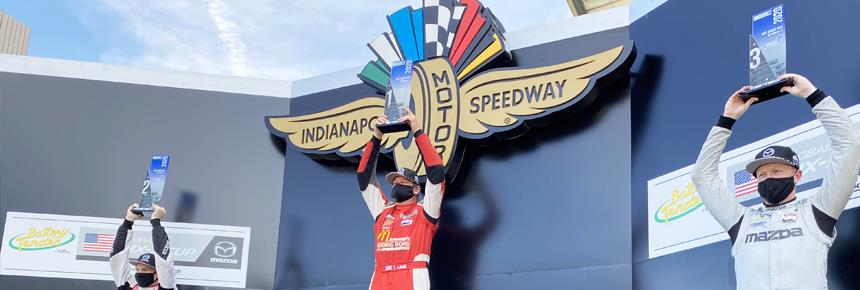 Todd Lamb raises a trophy on the Indianapolis Motor Speedway podium